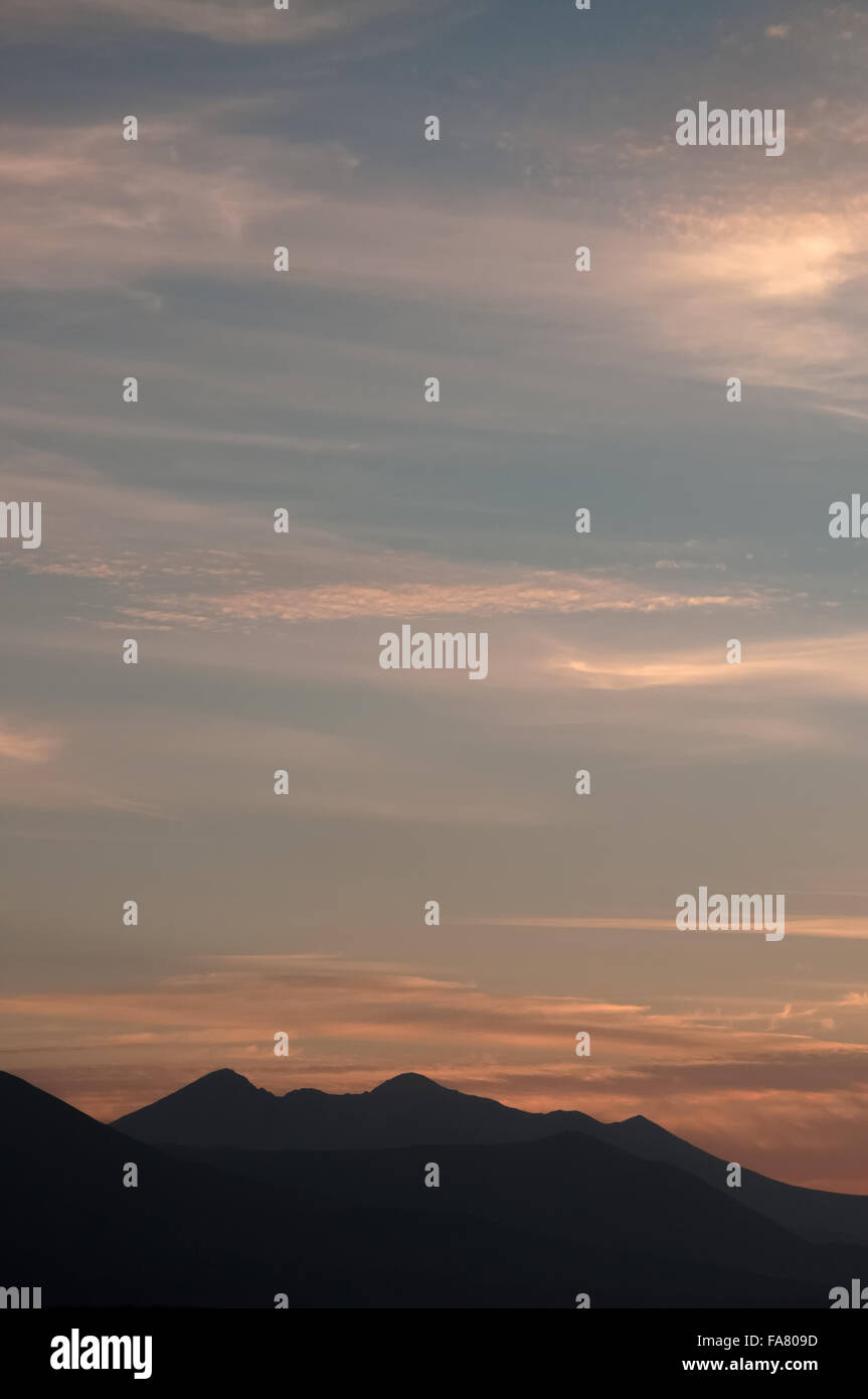 Il crinale di montagna Reeks e il Carrauntoohil contorni in un lontano al crepuscolo nella contea di Kerry, Irlanda, Europa Foto Stock
