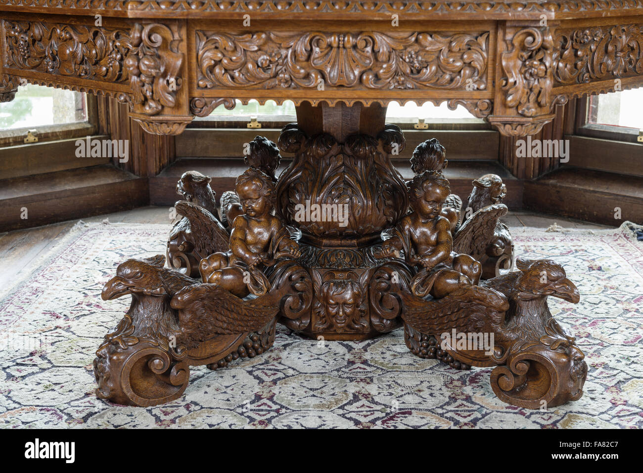 Dettaglio del Malfait intagliato tavolo da pranzo, nella piccola sala da pranzo, Oxburgh Hall, Norfolk. La base di questo tavolo ottagonale è stato realizzato per la famiglia Bedingfeld nei primi anni del XIX secolo, da armadio belga maker Malfait. Foto Stock