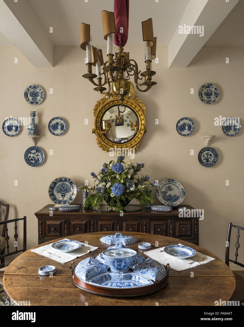 Blu e bianco ceramica sul tavolo e credenza e parete nella sala da pranzo, Nymans, West Sussex. Foto Stock