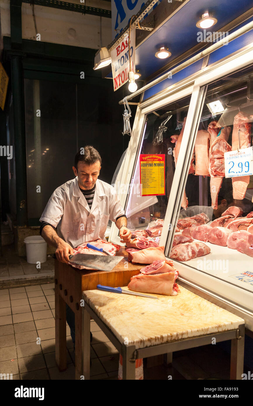 Butcher al mercato centrale di Atene, anche Varvakios Agora o Dimotiky Agora, mercato tradizionale sale vendita di alimenti freschi locali Foto Stock