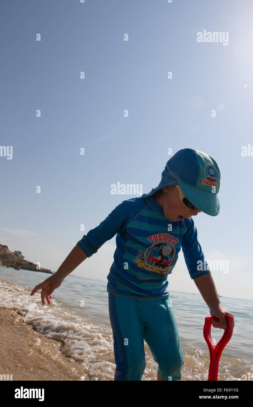 Ragazzo giocando sulla spiaggia di Praia de Santa Eulalia, nei pressi di Albufeira, Algarve, PORTOGALLO Foto Stock