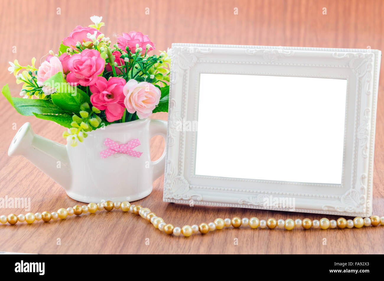 Vaso di fiori e vintage white cornice immagine sulla scrivania in legno, tracciato di ritaglio Foto Stock