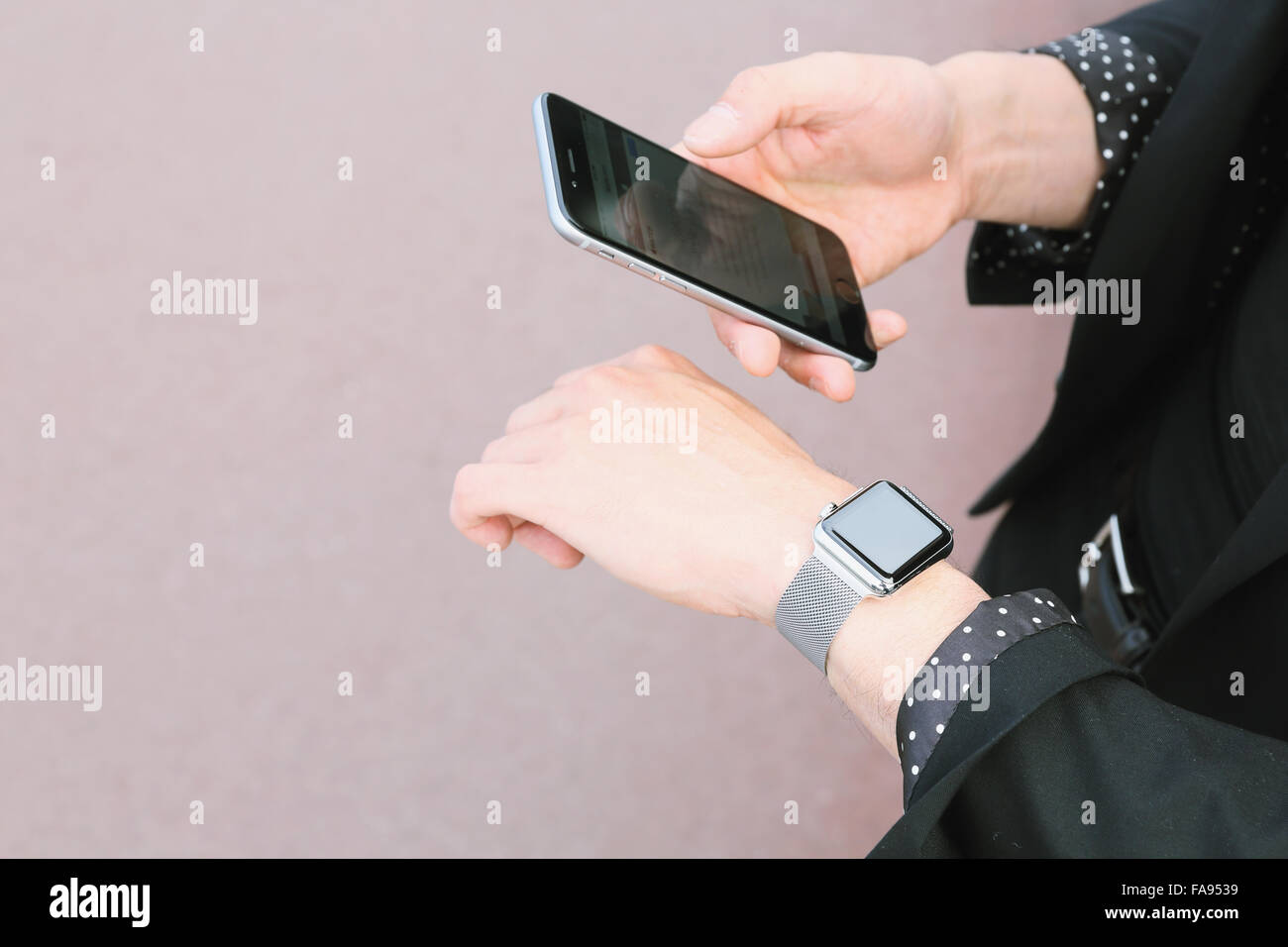 Imprenditore giapponese con smart indossabile guarda e lo smartphone Foto Stock