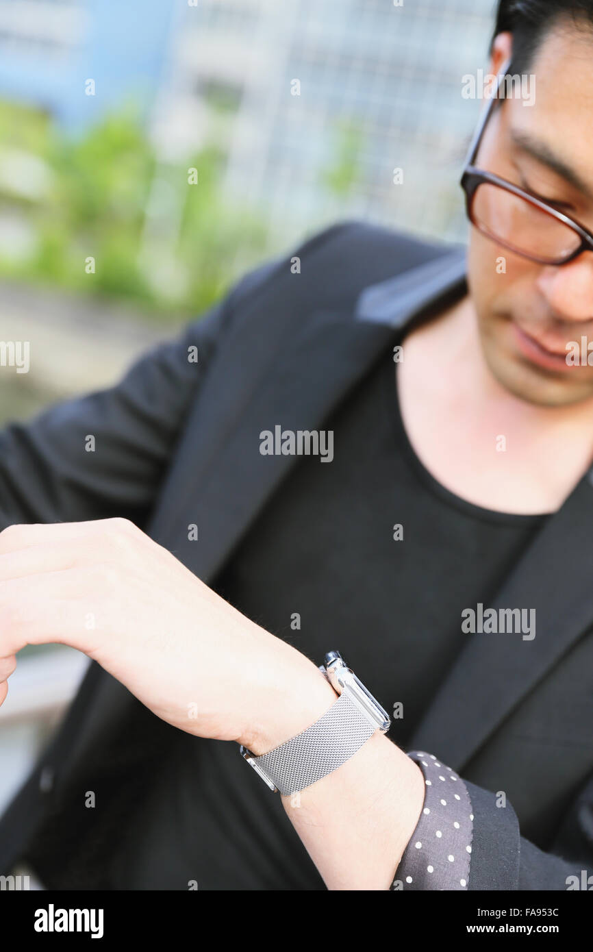 Imprenditore giapponese con smart indossabile watch Foto Stock