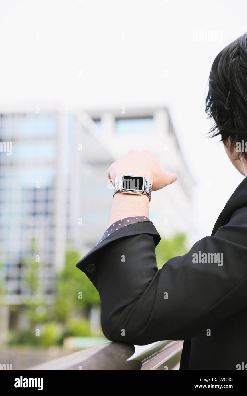 Imprenditore giapponese con smart indossabile watch Foto Stock