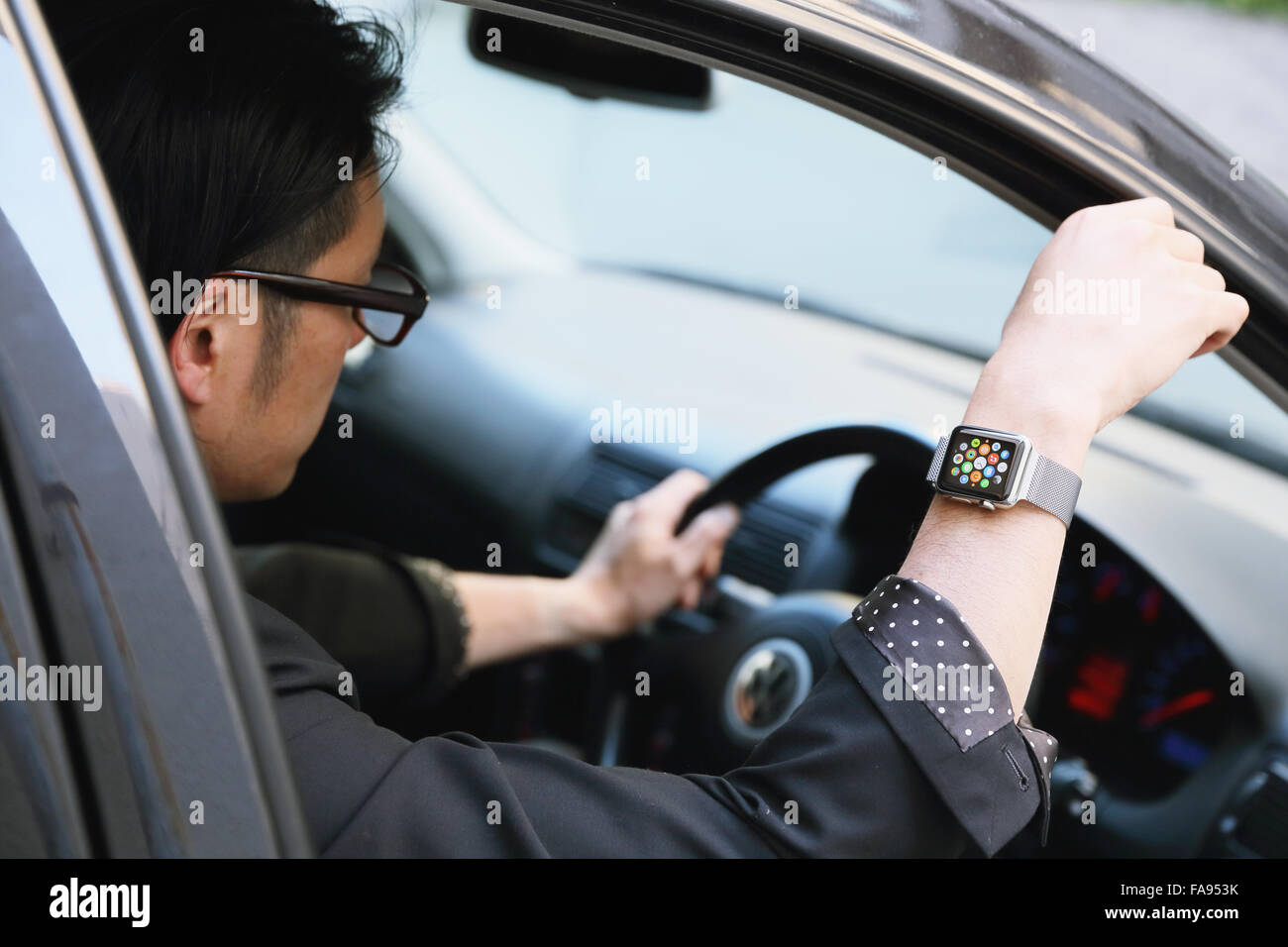 Uomo giapponese in auto con wearable smart watch Foto Stock