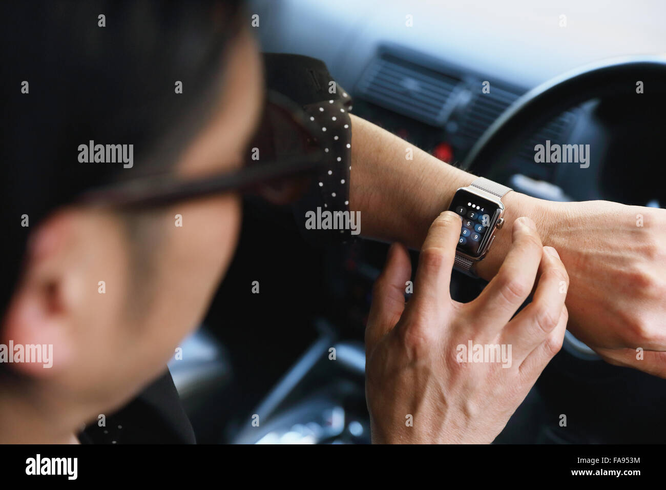 Uomo giapponese in auto con wearable smart watch Foto Stock