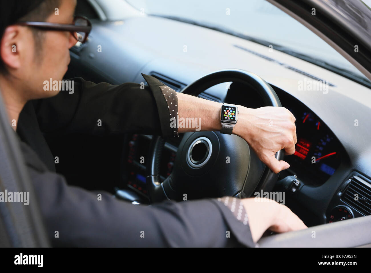 Uomo giapponese in auto con wearable smart watch Foto Stock