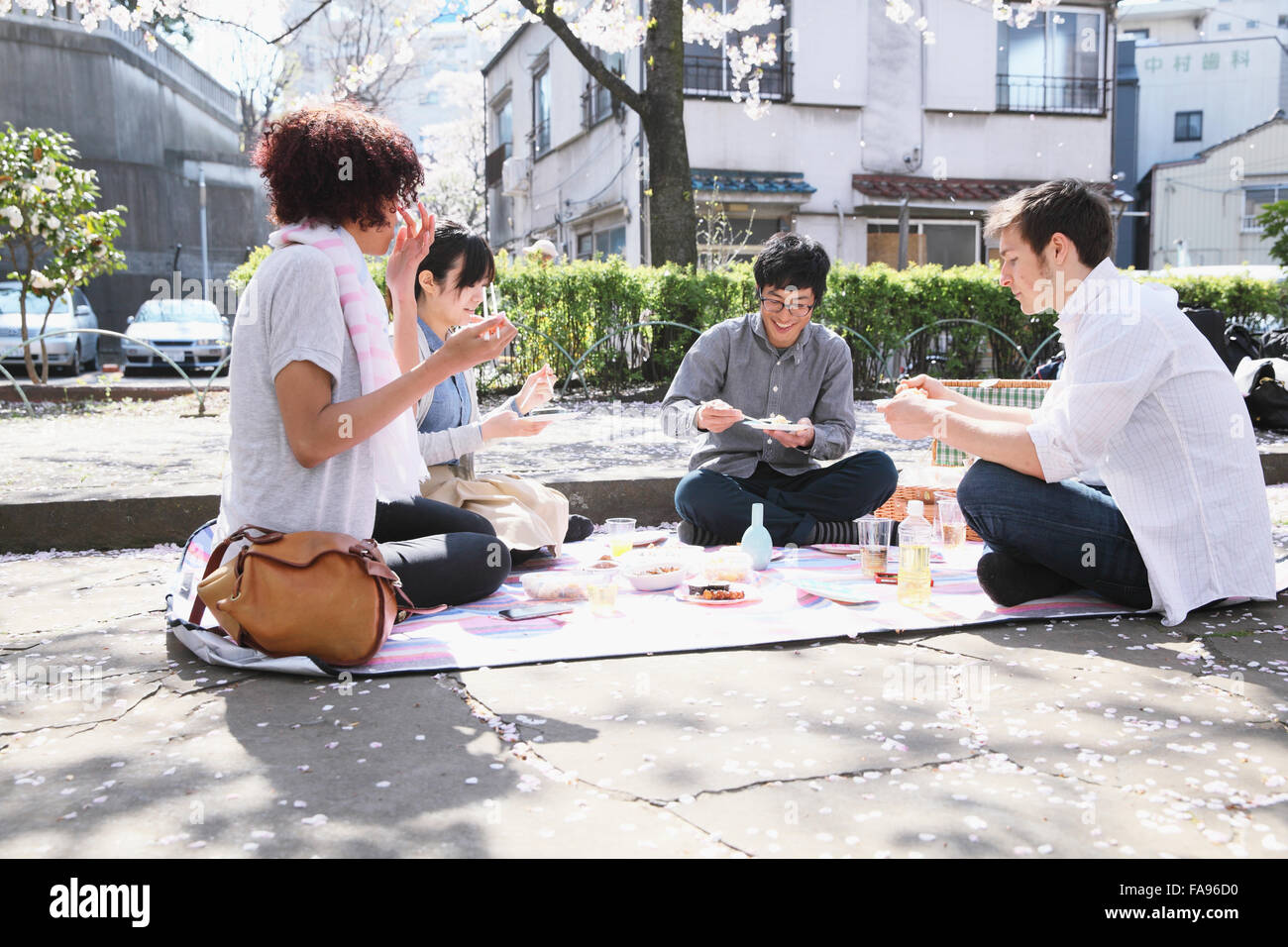 Multi-etnico gruppo di amici gustando la fioritura dei ciliegi in fiore nel Tokyo Foto Stock