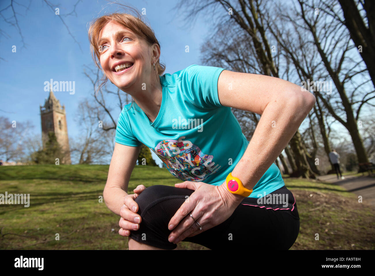 Un pareggiatore femmina indossando un tracker di attività di stretching prima di una corsa REGNO UNITO Foto Stock