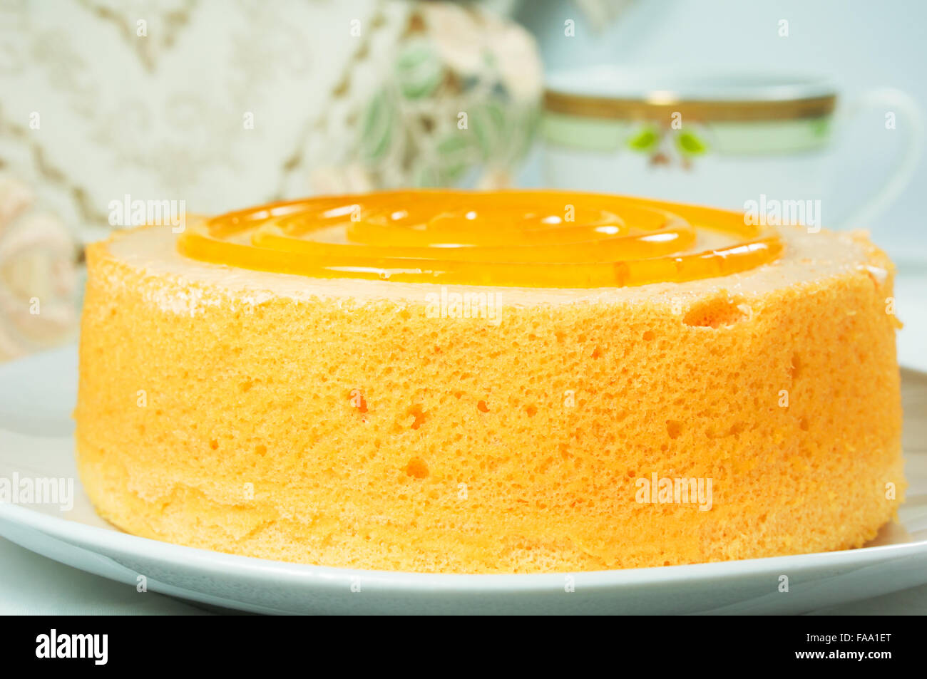 Closeup spugna arancio dolce torta con tè sul tavolo Foto Stock