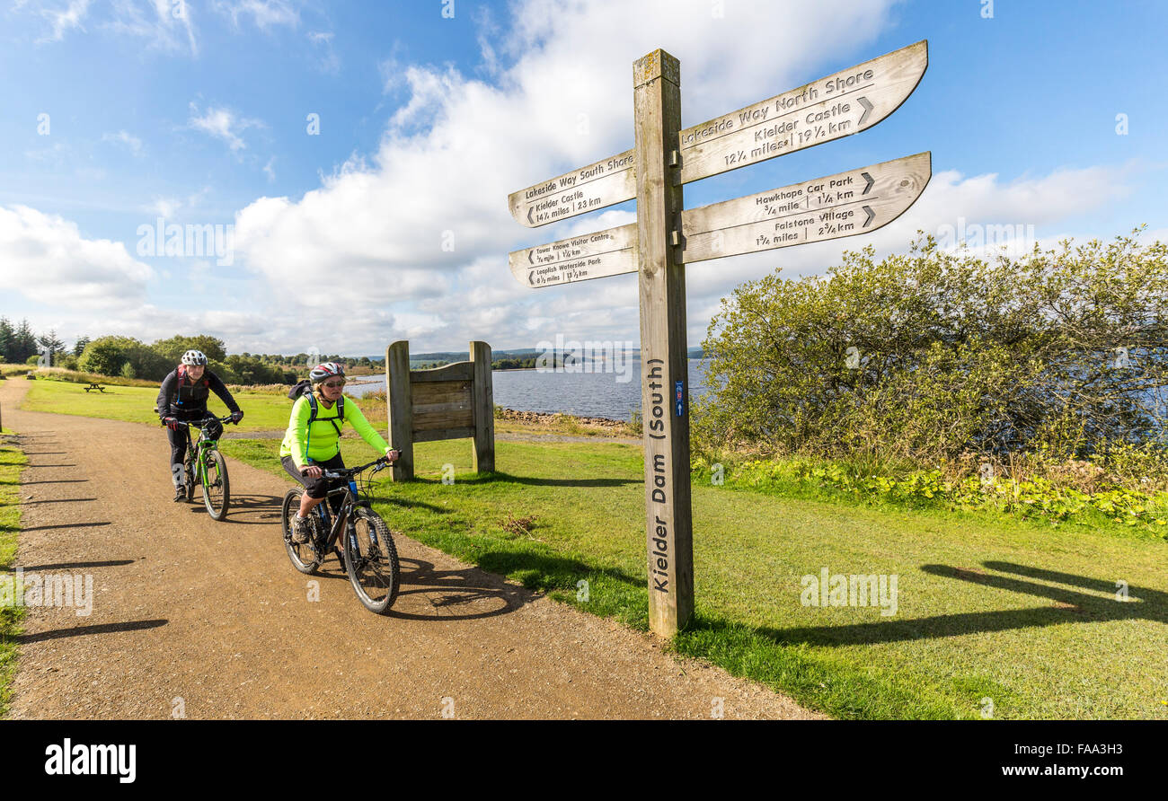 I ciclisti a Kielder diga con signpost, Northumberland, England, Regno Unito Foto Stock