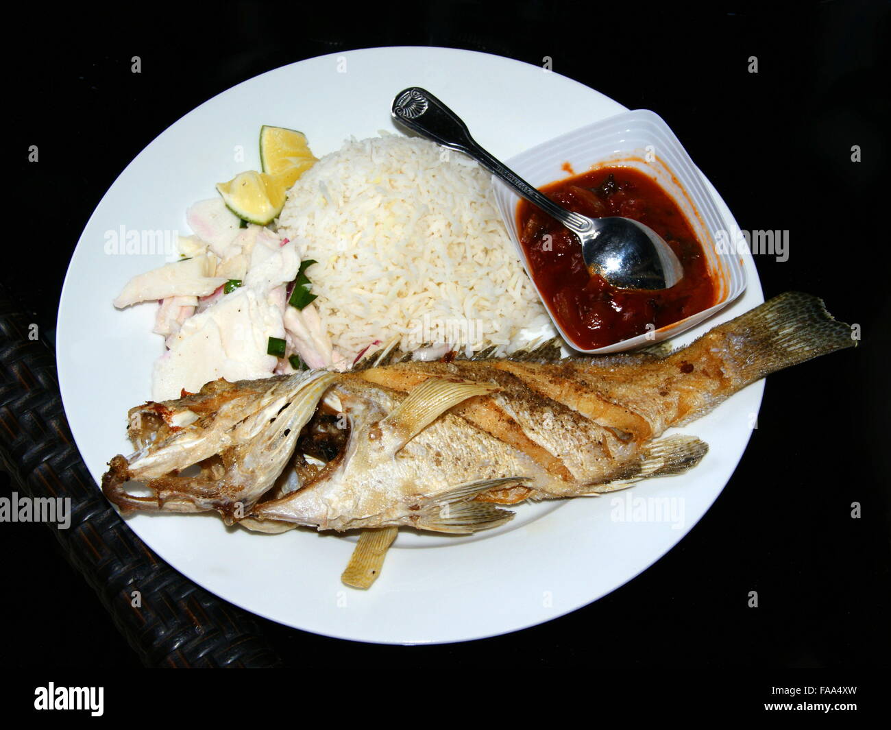 La cucina delle Seychelles. Pesce grigliato con salsa di tamarindo. Riso  bollito e di cuore di palma contorno di insalata Foto stock - Alamy