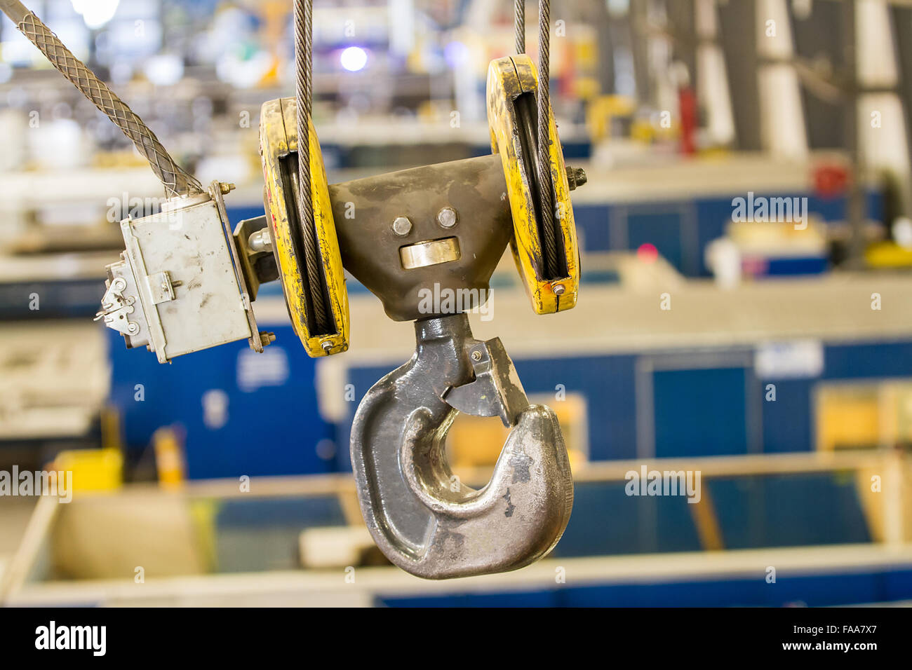 C gancio con gancio di sicurezza sospeso sopra la fabbrica di treccia di acciaio e cavi elettrici scatola del verricello Foto Stock