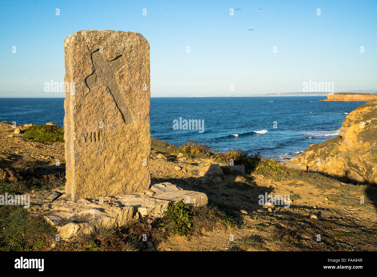 Tramonto a pietra con croce alla costa di peniche portogallo Foto Stock