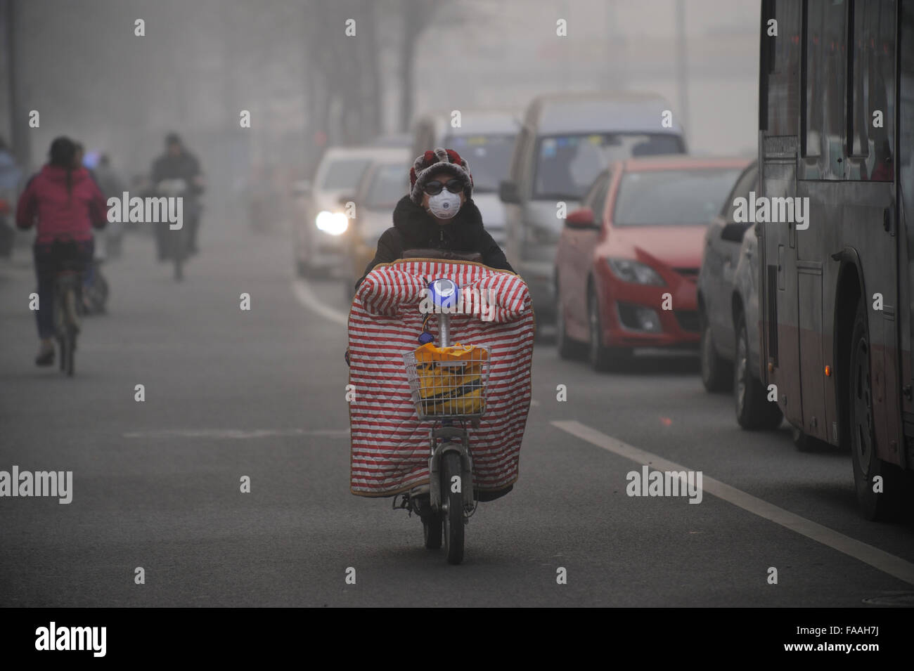 Persone indossano maschere come una densa foschia dell inquinamento dell aria buste di Beijing in Cina. 25-Dec-2015 Foto Stock