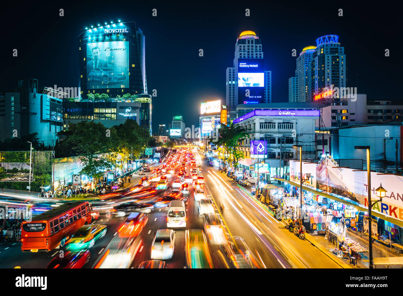 Una lunga esposizione di traffico e di moderni edifici su Ratchadamri Road di notte, al Siam, a Bangkok, in Thailandia. Foto Stock