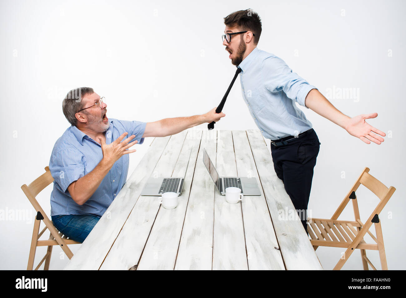 Conflitto aziendale. I due uomini che esprimono la negatività mentre un uomo afferrando la cravatta del suo avversario Foto Stock