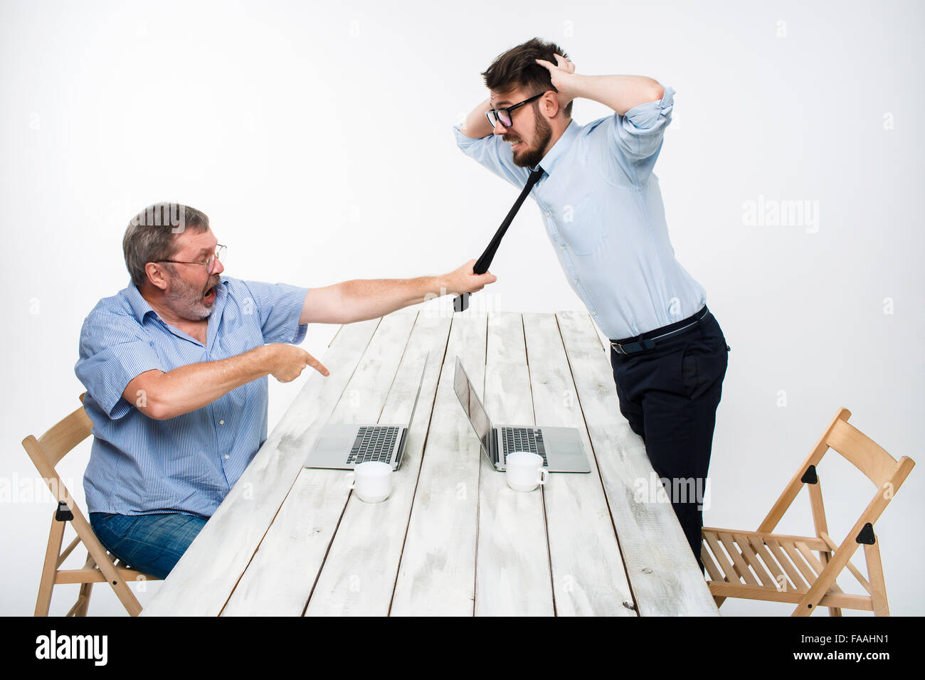 Conflitto aziendale. I due uomini che esprimono la negatività mentre un uomo afferrando la cravatta del suo avversario Foto Stock