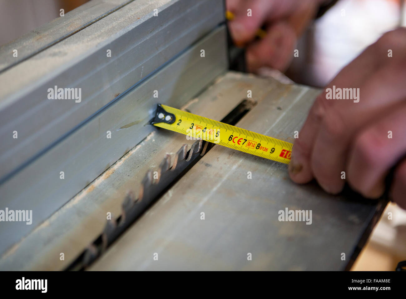 Carpenter lavora con i montanti delle porte utilizzando sega circolare elettrica. Egli è la misura della zona di taglio Foto Stock