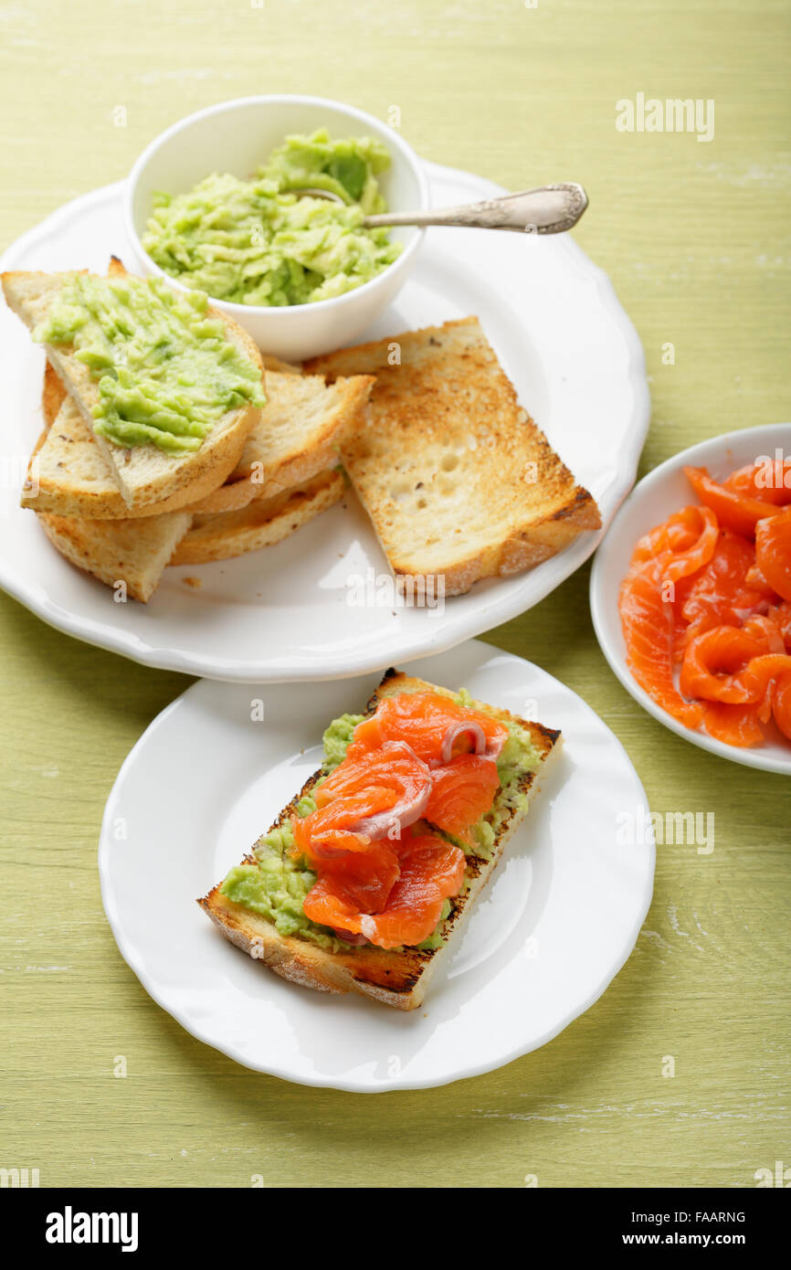 Toast con salmone e avocado, cibo closeup Foto Stock