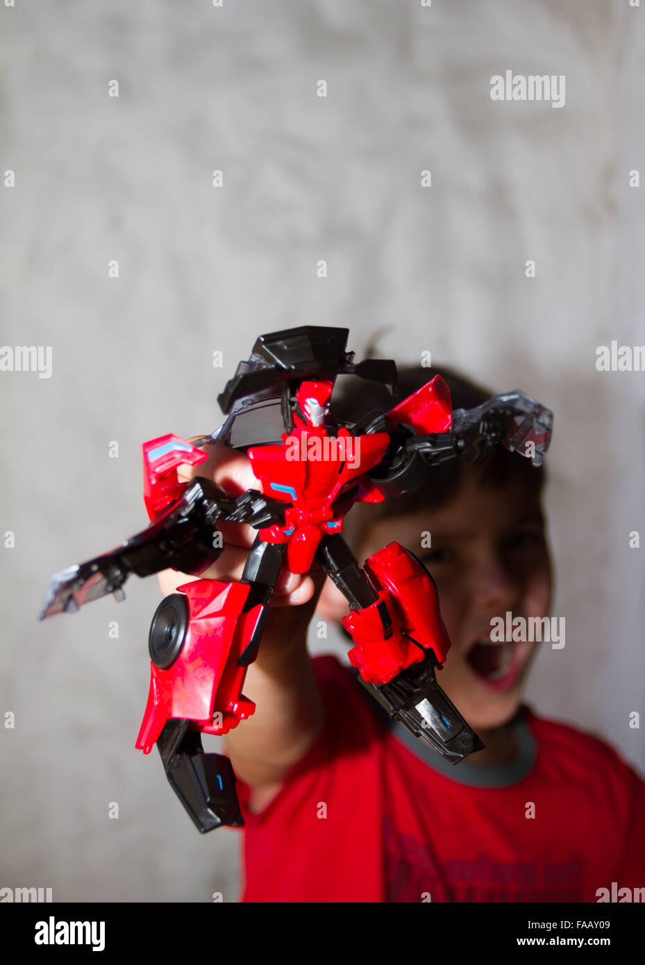 Il Toddler boy mostra fuori il suo trasformatore giocattolo. Foto Stock