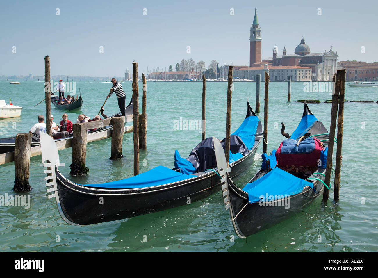 Persone turistiche e delle gondole ancorate ai poli sul Canal Grande Foto Stock