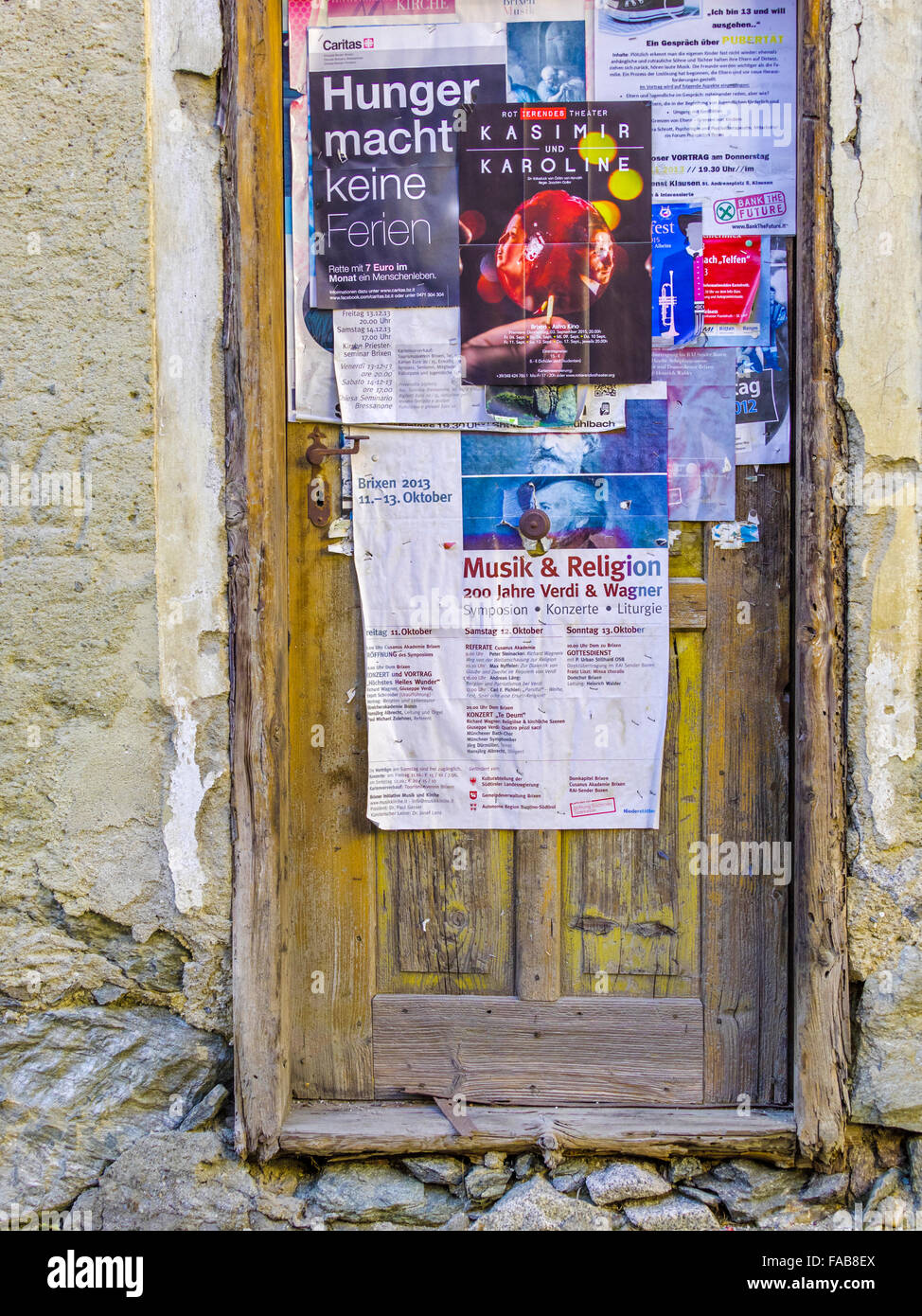 Porta rustica e manifesti nella città di Barbiano nel Nord Italia Foto Stock