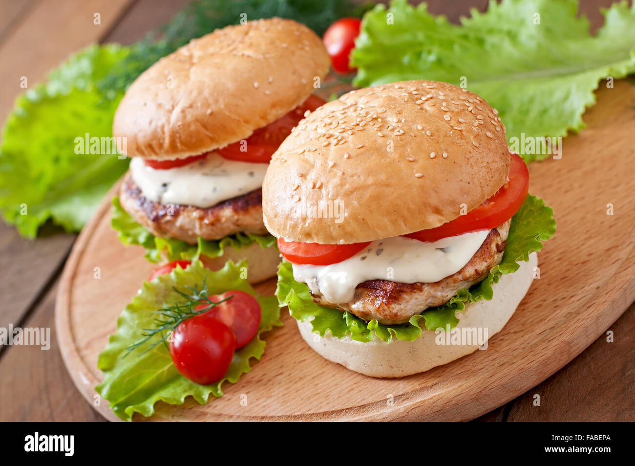 Appetitosi hamburger con hamburger di pollo con la salsa tartara Foto Stock