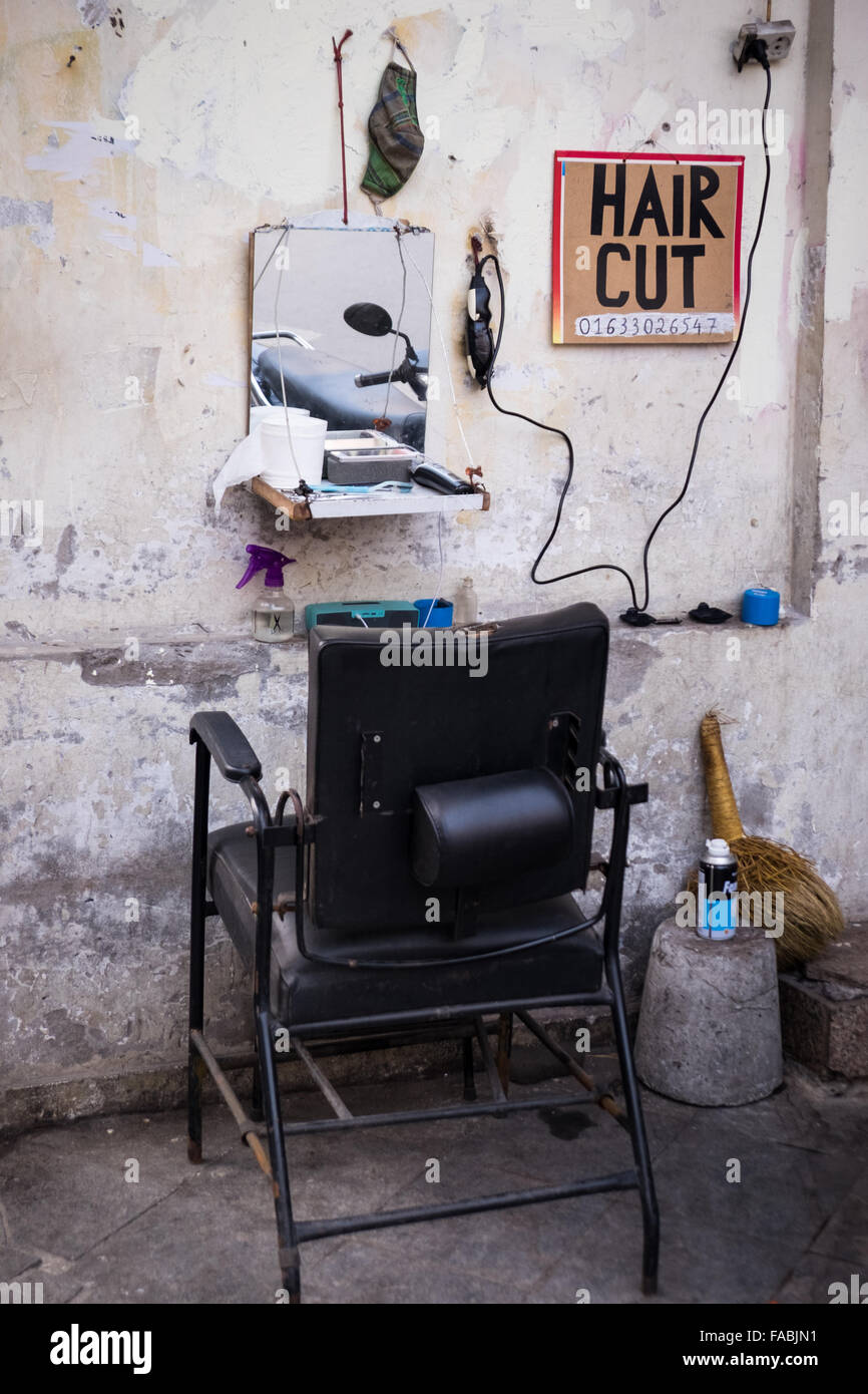 Una strada barbieri offrendo a buon mercato i tagli di capelli nella città vecchia di Hanoi e. Foto Stock