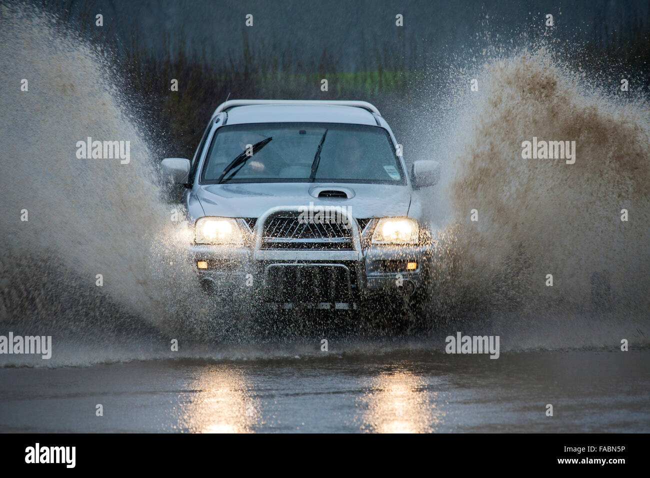 La guida attraverso l'alluvione sulla strada di un paese nel Nord Yorkshire nel Regno Unito. Foto Stock