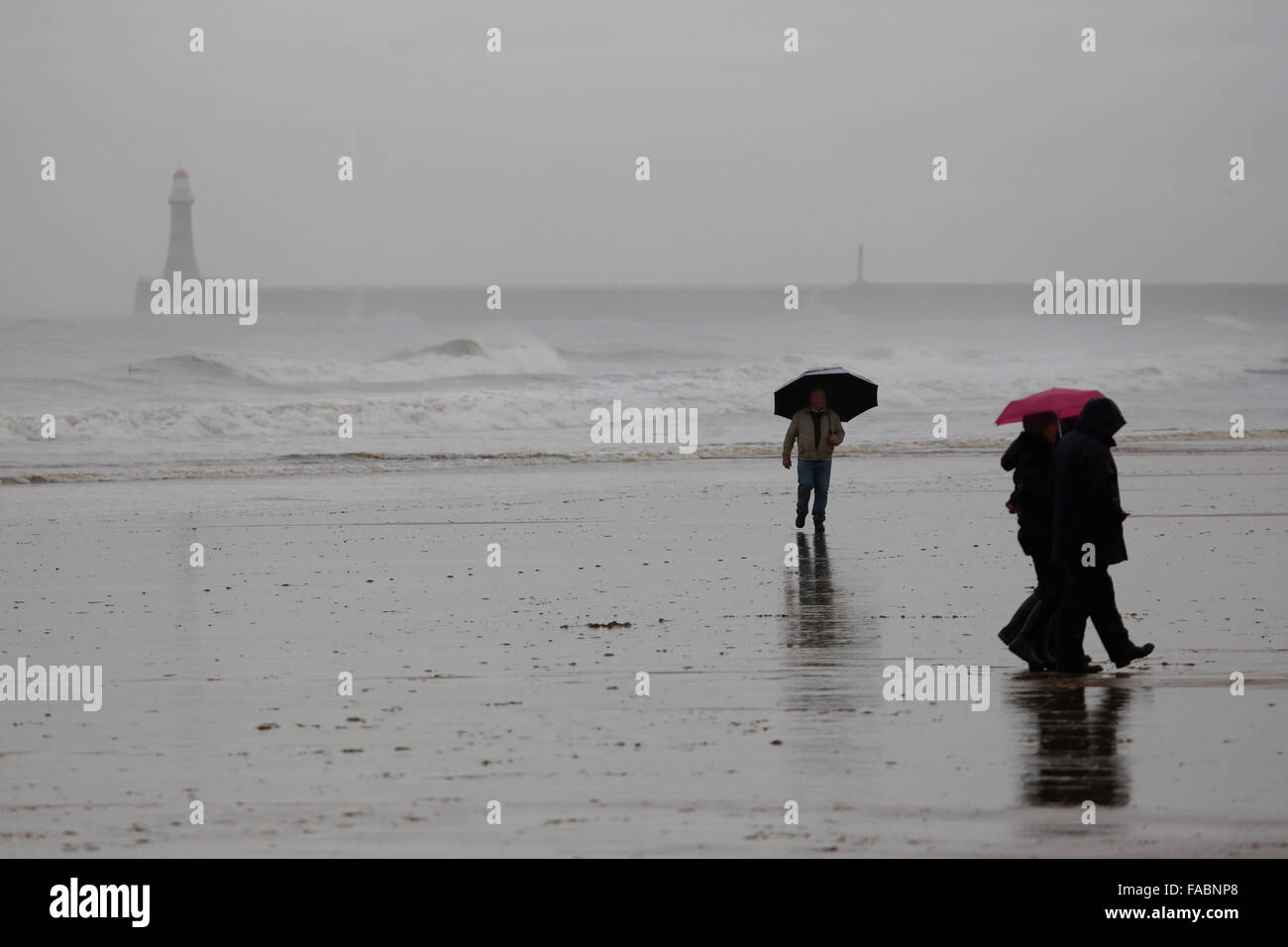Sunderland, Regno Unito. 26 dicembre, 2015. La gente a piedi sulla spiaggia a Seaburn dopo il Boxing Day Dip a Sunderland, Inghilterra. Depite heavy rain migliaia di spettatori ruotato fino all'evento annuale. Credito: Stuart Forster/Alamy Live News Foto Stock