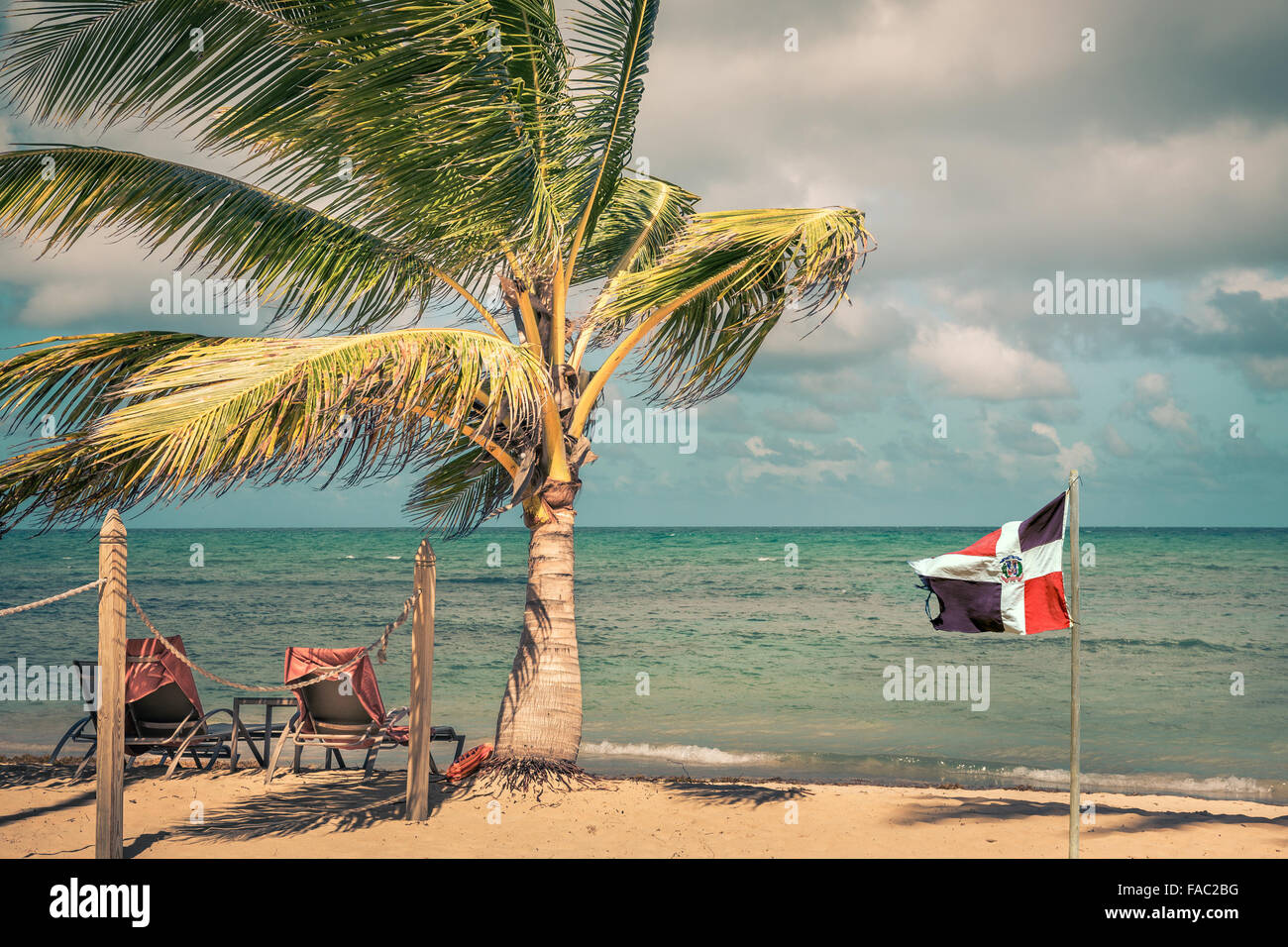 Bandiera della Repubblica Dominicana presso la spiaggia e il mare dei Caraibi in background Foto Stock
