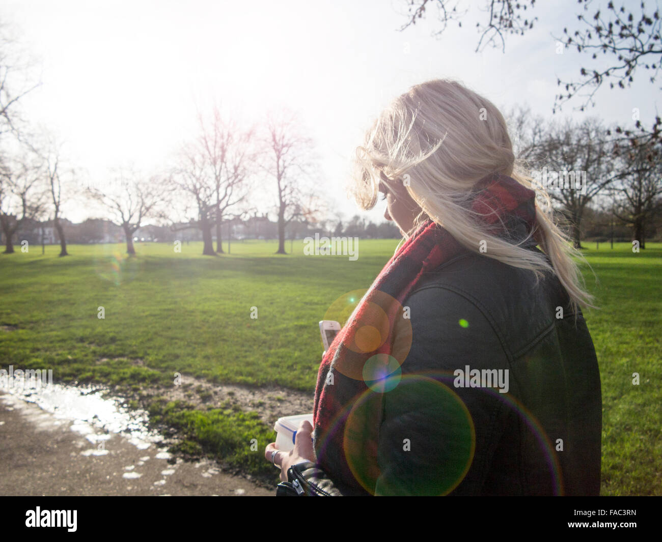 Una ragazza bionda su una passeggiata invernale in una giornata di sole Foto Stock