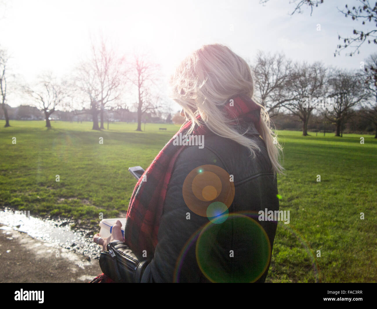 Una ragazza bionda su una passeggiata invernale in una giornata di sole Foto Stock