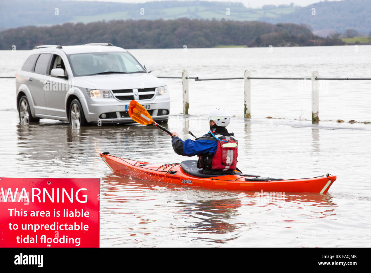 Kayakers nelle acque di esondazione su strada a Storth sul Kent Estuary in Cumbria, Regno Unito, durante il mese di gennaio 2014 mareggiata e h Foto Stock