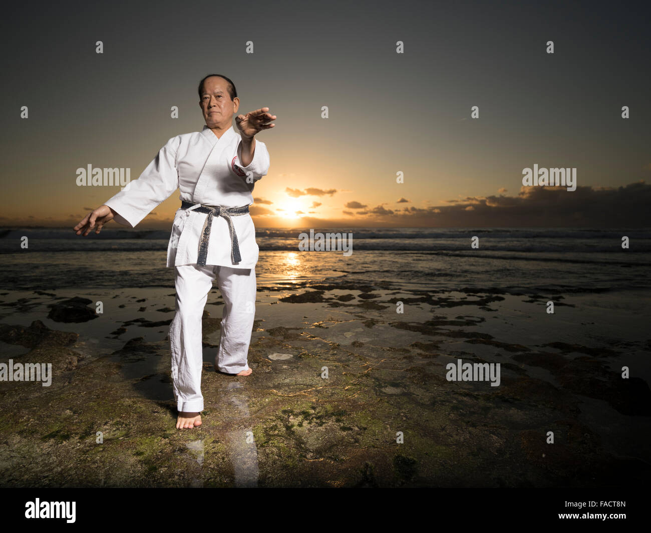 Karate master Hiroshi Takamiyagi (75) Formazione sul Seawall Sunabe, Okinawa, in Giappone. 18 Dic 2015 Foto Stock