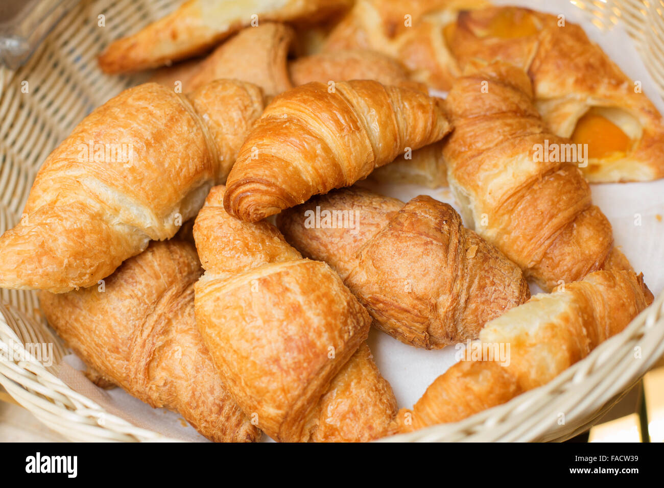 Mazzetto di cornetti freschi in un cesto di paglia Foto Stock