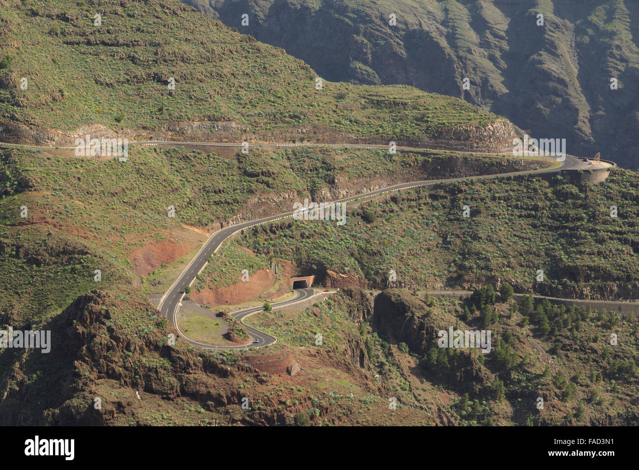 Una fotografia di una strada tortuosa che conduce in un tunnel nelle montagne sopra la Valle Gran Rey a La Gomera, isole Canarie, Spagna. Foto Stock