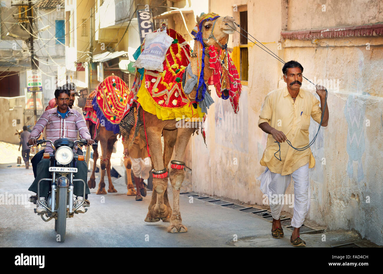 Udaipur street scene, india uomo porta un cammello e moto sulla strada, Udaipur, India Foto Stock
