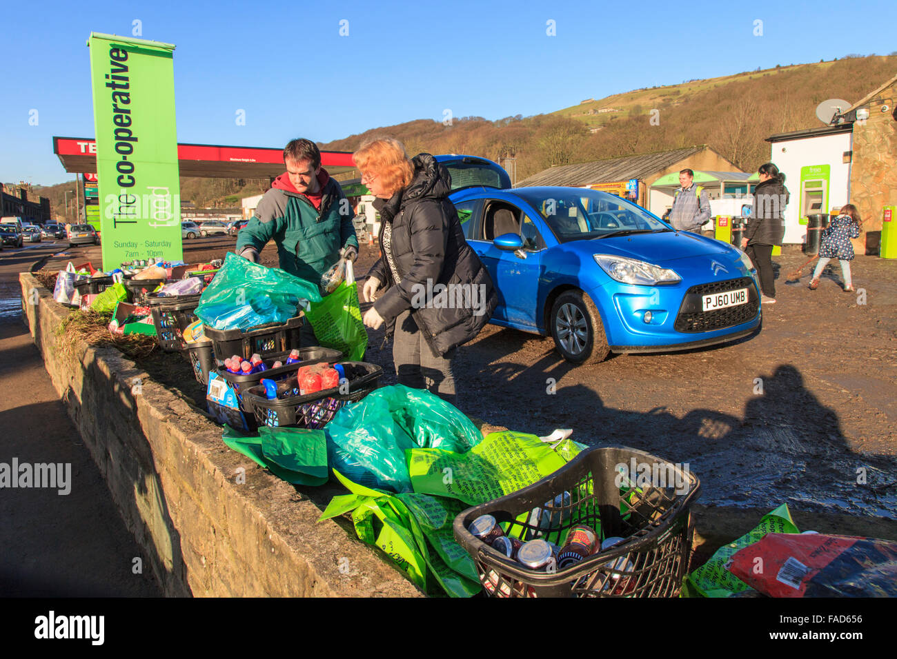 Mytholmroyd, REGNO UNITO, 27 Dic, 2015. Il personale dando via libera di prodotti per la pulizia al di fuori del supermercato Co-Operative in Mytholmroyd, a seguito delle inondazioni su Boxing day 2015 Credit: Graham Hardy/Alamy Live News Foto Stock