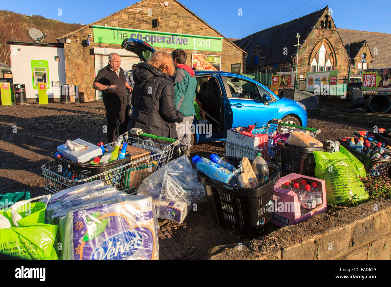 Mytholmroyd, REGNO UNITO, 27 Dic, 2015. Il personale dando via libera di prodotti per la pulizia al di fuori del supermercato Co-Operative in Mytholmroyd, a seguito delle inondazioni su Boxing day 2015 Credit: Graham Hardy/Alamy Live News Foto Stock