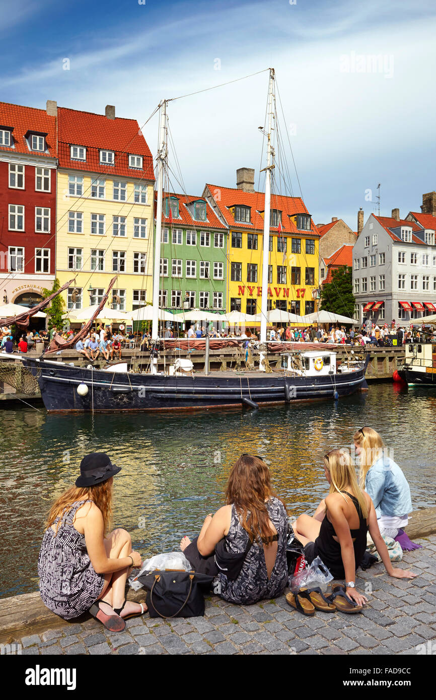 Turisti in un momento di relax a Nyhavn Canal, Copenhagen, Danimarca Foto Stock