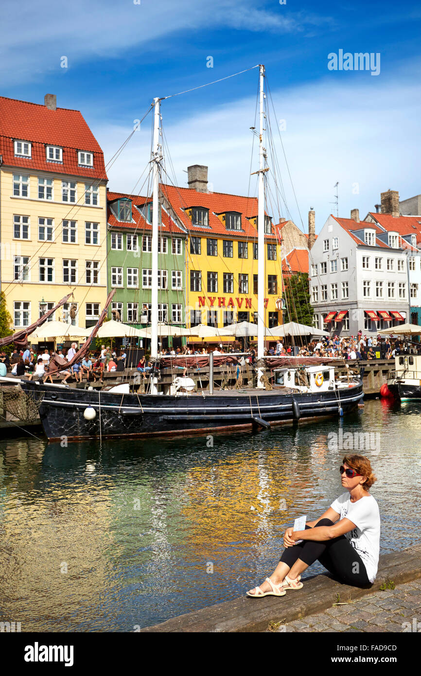 Turist rilassante a Nyhavn Canal, Copenhagen, Danimarca Foto Stock