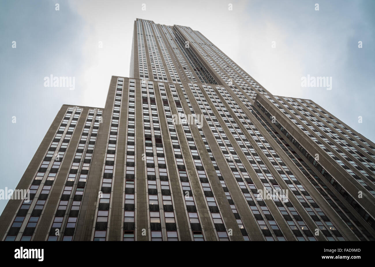 L' Empire State Building a New York City il colpo da sotto, guardando verso l'alto verso un blu cielo nuvoloso. Foto Stock