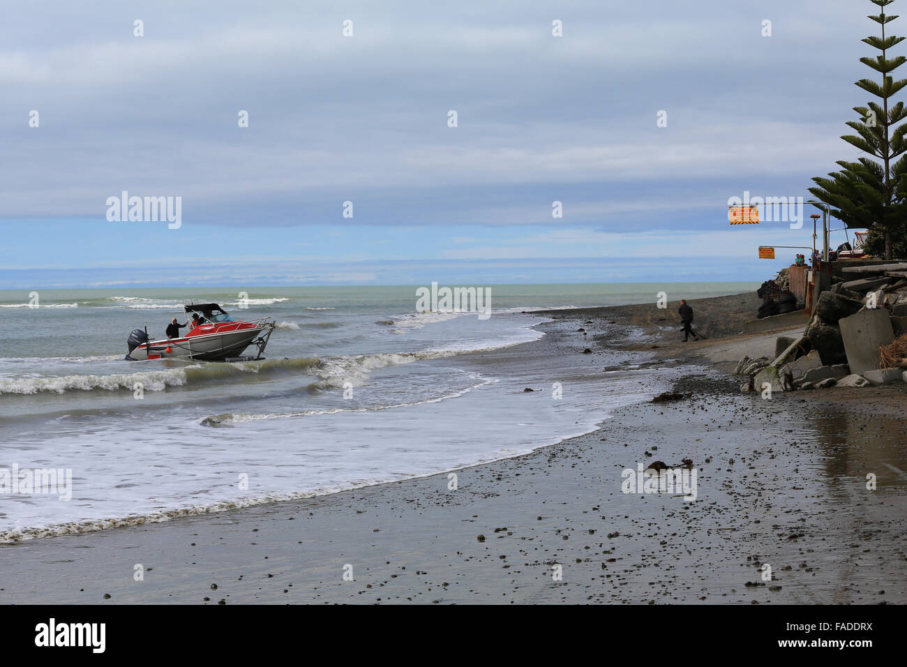 Un pescatore McLay barca è trasportata fuori dall'acqua in tutta la spiaggia su una barca rimorchio in Clifton, Hawke's Bay, Nuova Zelanda. Foto Stock