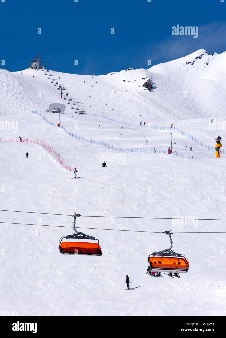 Gli sciatori, seggiovia arancione e corso di slalom in Alpine Ski resort in Solden nelle Alpi Otztal, Tirolo, Austria Foto Stock