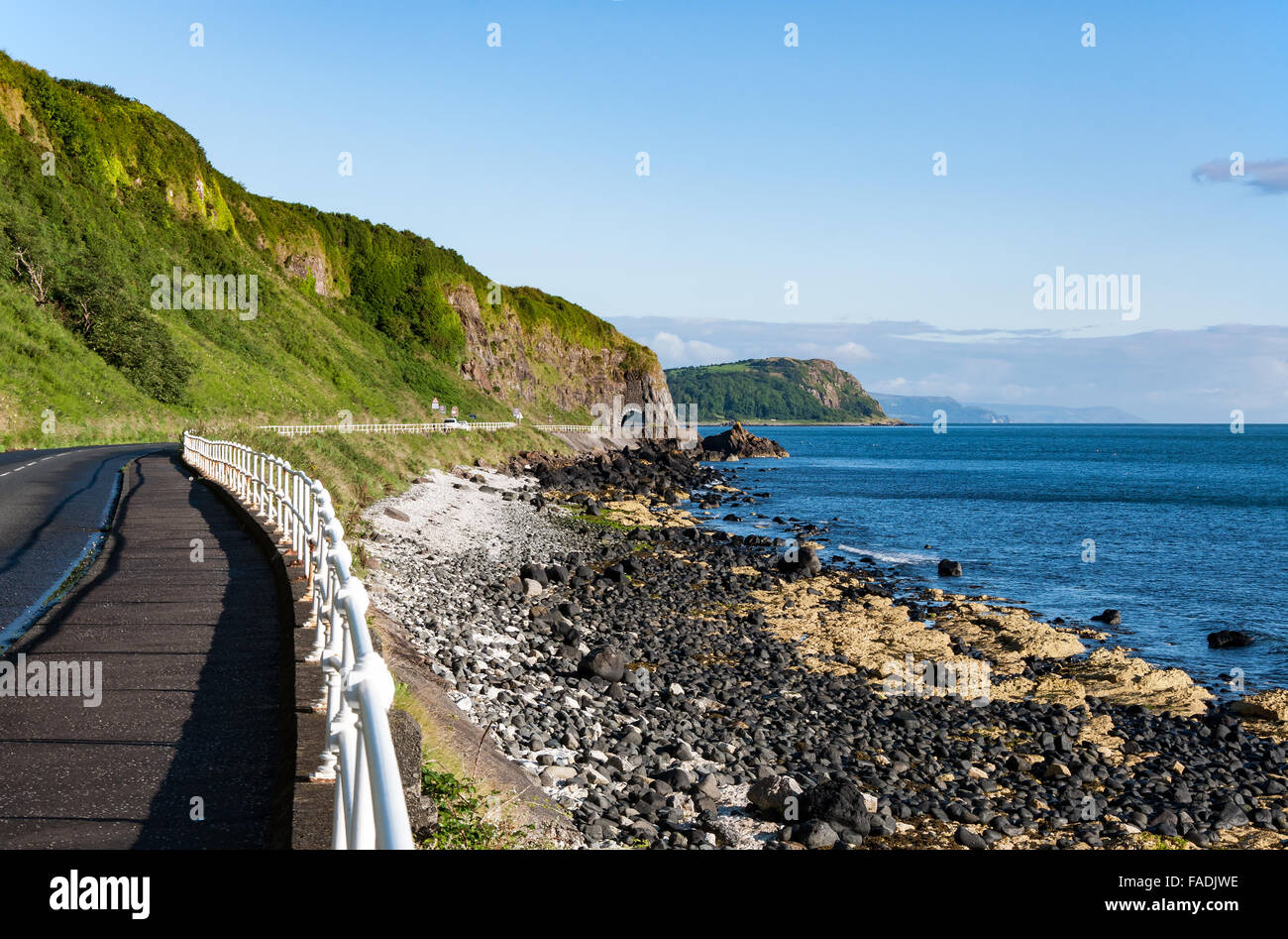 La costa orientale dell'Irlanda del Nord e di Antrim strada costiera con un tunnel Foto Stock