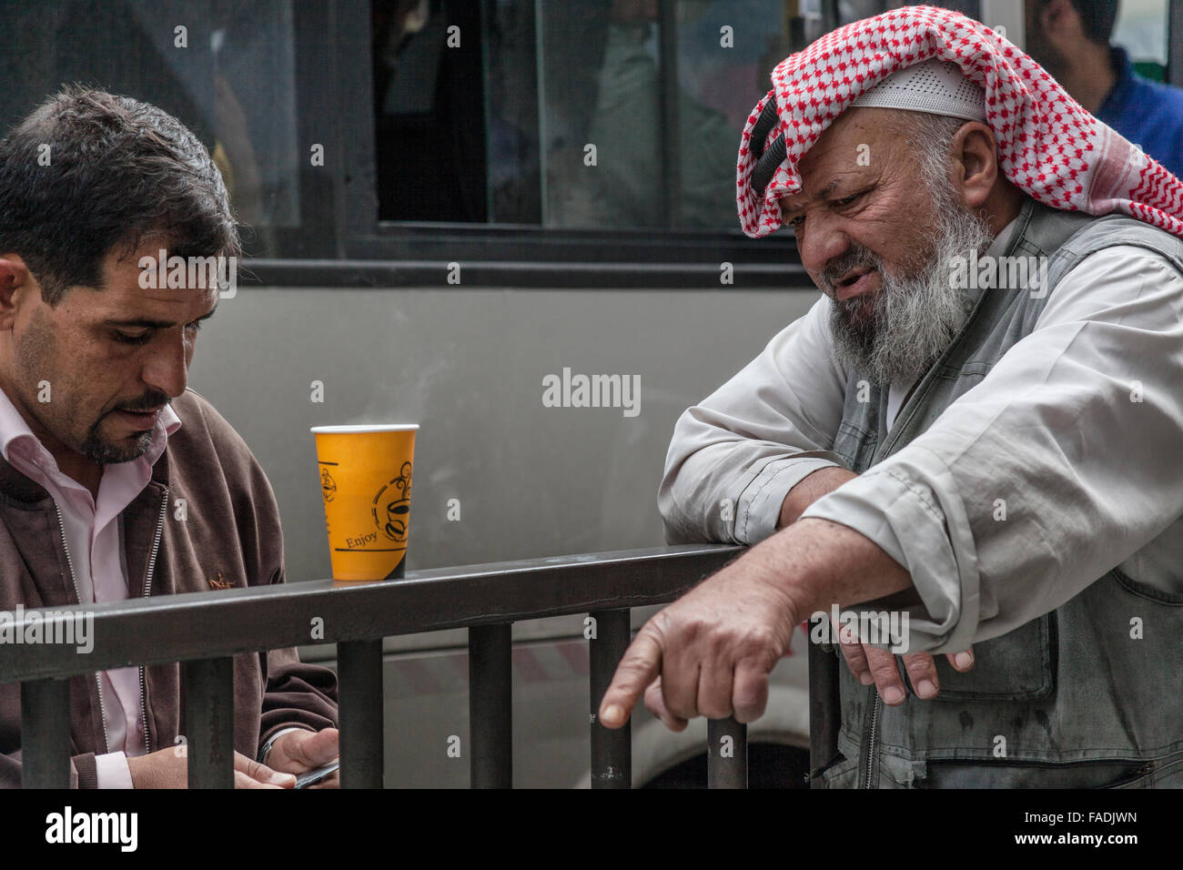 Due uomini arabi in abito moderno e gli altri in abito tradizionale, Amman, Giordania Foto Stock