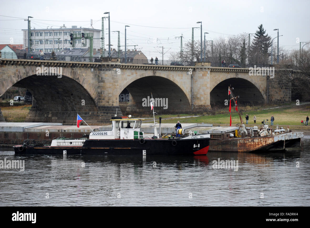 Drazdany, Germania. 28 dicembre, 2015. Rimorchiatore ceca (retro) è inceppato sotto il Marienbruecke ponte sul fiume Elba a Dresda, Germania, 28 dicembre 2015. Il Labe (Elba) Autorità di Bacino del fiume ha inviato un'onda lungo il fiume per aiutarci a salvare un ceco nave da carico. Il 90 metri di nave con un carico di peso 1100 tonnellate è rimasto bloccato in Germania durante il suo viaggio a Decin, Boemia settentrionale, domenica 27. Foto di fronte rimorchiatore che sono arrivati per aiutare la barca ceca. © Libor Zavoral/CTK foto/Alamy Live News Foto Stock